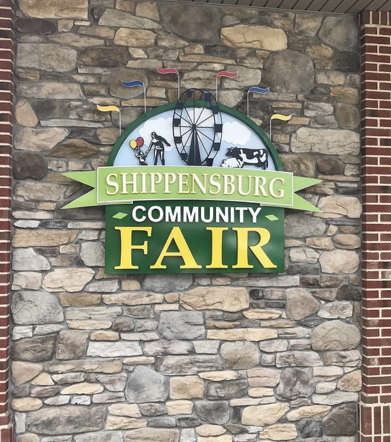 Shippensburg Community Fair sign on stone wall